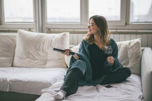 Young woman relaxing in the livingroom ,drinking wine and watching tv